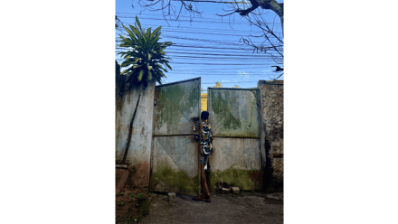 A child looks through a metalic door in Salvador di Bahia, Brazil